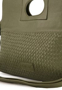 Olijfgroene leren handtas met een geweven textuur aan de onderkant, een ronde uitsnijding voor de handgreep en een logo patch. Inclusief schouderriem.