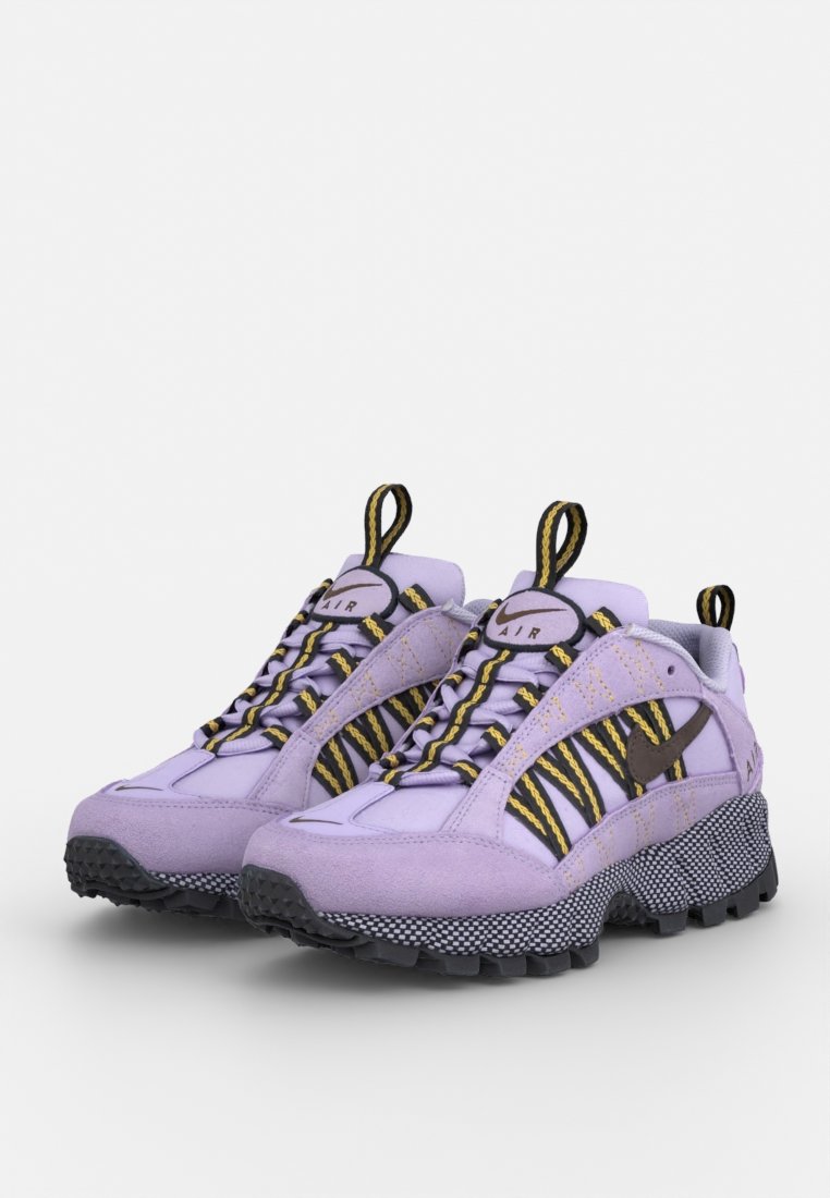 Baskets en suède violet avec des accents rayés jaunes et noirs, une semelle intermédiaire en maille texturée et une semelle extérieure en caoutchouc noir bien marquée.