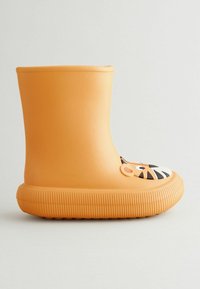 Botte en caoutchouc orange avec un motif de visage de tigre sur le bout, texture lisse, forme arrondie et semelle à rainures horizontales.
