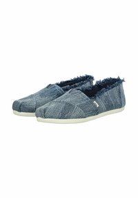 Scarpe slip-on in denim con bordo sfrangiato, tessuto blu testurizzato, punta arrotondata e suola in gomma bianca. Design semplice per un look casual.