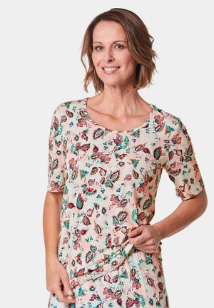 Blumenbluse mit kurzen Ärmeln in zartem Pfirsich, mit grünen und roten Blumenmustern, runder Ausschnitt und weichem Stoff. 