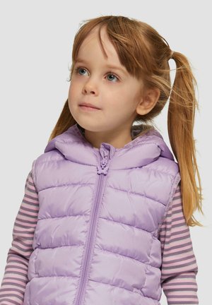 Lilafarbene Puffer-Weste mit Kapuze, ausgestattet mit einem gesteppte Textur und einem Reißverschluss; getragen über einem langärmeligen gestreiften Hemd mit rosa und grauen Streifen.