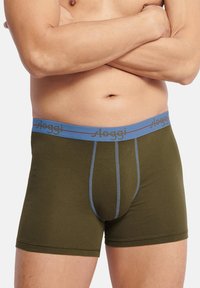 Olivgrön boxershorts med en ljusblå midjeband som har varumärket "sloggi" i en kontrasterande färg. Elastiskt material med sydda detaljer.