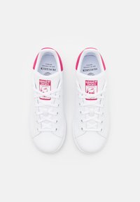 Vita sneakers med rosa accenter, med en slät syntetisk ovandel, rund tå och klassisk snörning. Logotyp på tungan och hälen.