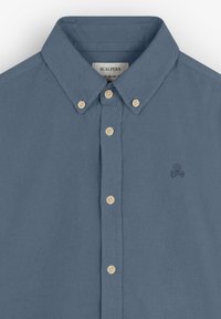 Camisa de botones en azul pizarra, material de algodón. Presenta un cuello clásico, cinco botones y un pequeño logo de calavera bordado en marino.