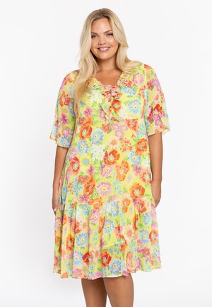 Gelbes Blumenmaxikleid mit kurzen Ärmeln, das mit lebhaften mehrfarbigen Blumen und einem gestuften Volantabschluss versehen ist. Leichter, weicher Stoff.