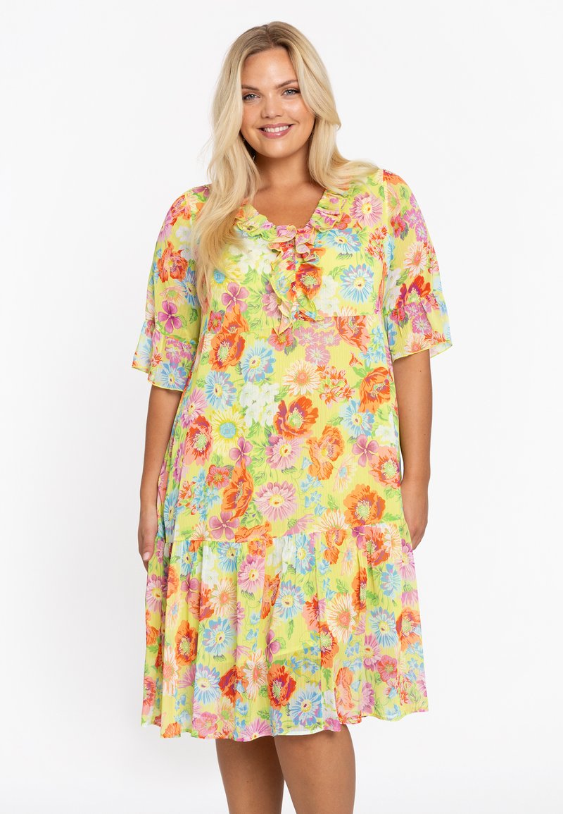 Gelbes Blumenmaxikleid mit kurzen Ärmeln, das mit lebhaften mehrfarbigen Blumen und einem gestuften Volantabschluss versehen ist. Leichter, weicher Stoff.