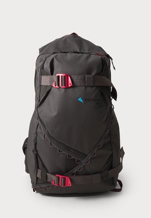 Black backpack with pink hardware, featuring a scalloped edge design, adjustable straps, and multiple pockets. Made of durable fabric.