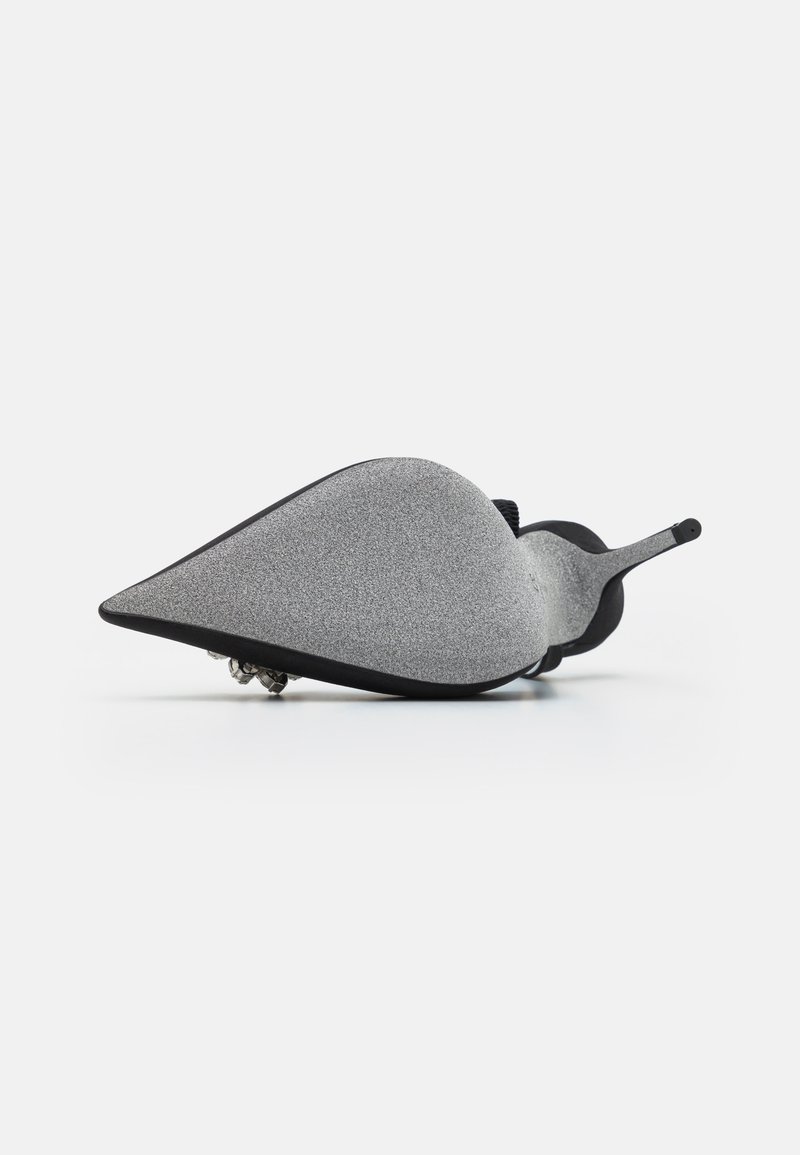 Chaussure grise à bout pointu avec une texture lisse, des accents noirs et un détail décoratif en strass sur la semelle. Design élégant et moderne.