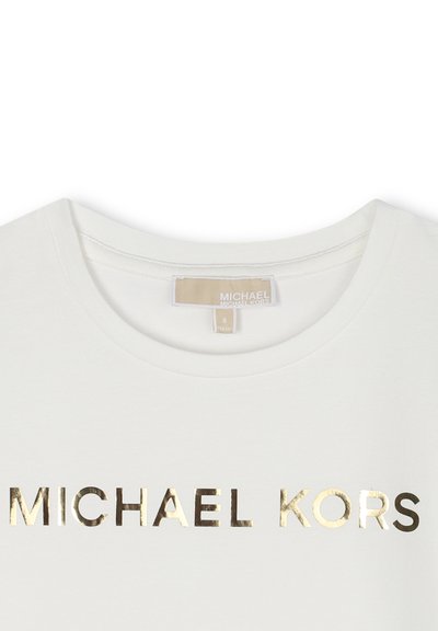 Vit T-shirt i bomull med rund halsringning. Har ett guldmetalliskt "MICHAEL KORS"-logotyp tvärs över bröstet. Storleksmärke synligt som "8."