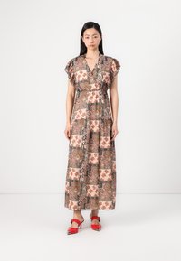 Maxi kleita ar rakstainu audumu, kas iestrādāts dabiski zemes toņos un ziedu motīvos. Īsas rūtainas piedurknes un pieguļošs vēders veido plūstošu siluetu.