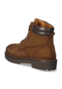 Brązowe zamszowe botki za kostkę z okrągłym noskiem, sznurowanym zapięciem, wyściełanym brązowym skórzanym kołnierzem oraz teksturowaną gumową podeszwą zapewniającą przyczepność.