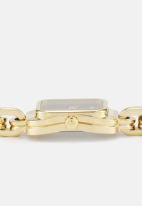 Montre en métal doré avec un boîtier rectangulaire, un cadran noir et un bracelet à maillons. Présente une couronne proéminente et un logo de marque gravé.
