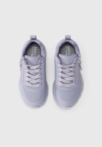 Un paio di sneaker Skechers lavanda con lacci, cerniere laterali e punte dei piedi perforate su uno sfondo bianco.