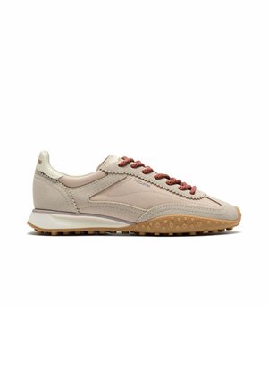Zapatilla de ante beige y marrón claro con cordones rojos, suela texturizada y diseño de perfil bajo, mostrada de perfil sobre fondo blanco.