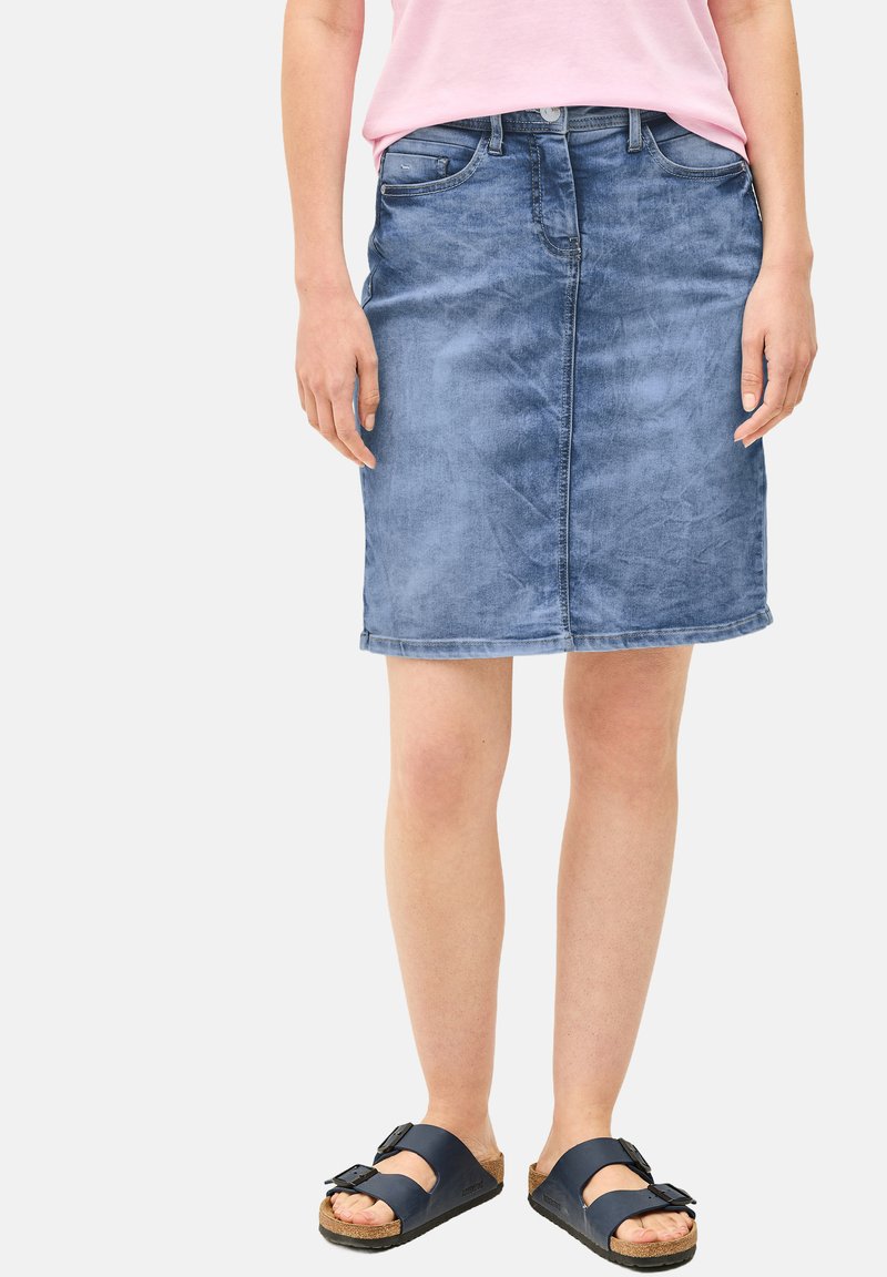 Hame denim vaaleansinisena suoralla leikkauksella, etutaskuilla ja raidoitetulla helmalla. Yhdistetty mustien sandaalien ja vaaleanpunaisen paidan kanssa.