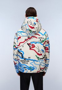 Isolierte Jacke mit weißem Grund und einem mehrfarbigen Kartenmuster. Verfügt über eine Kapuze und elastische Bündchen, beschriftet mit Höhenmarkierungen.