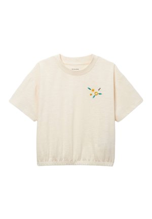 T-shirt beige à manches courtes avec ourlet élastique et petites fleurs jaunes brodées ainsi que des feuilles vertes près de la poitrine gauche.