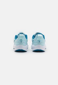 Baskets de sport bleu clair avec un dessus en mesh texturé, semelle intermédiaire blanche et semelle extérieure bleue. Équipées d'une languette au talon pour un enfilage facile.