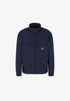 Giacca a zip blu navy con colletto alto, tessuto testurizzato, due tasche sul petto con pattina, tasche laterali con zip e polsini elasticizzati.