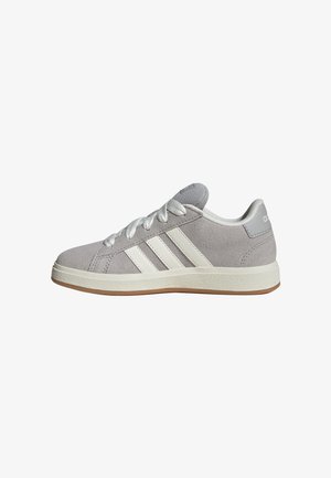 Sivá semišová teniska Adidas s bielymi tromi pásmi, bielymi šnúrkami a béžovou gumovou podrážkou, zobrazená z boku na bielom pozadí.