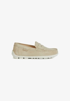 Beige Wildleder-Slipper mit weißer Gummisohle, dekorativer Stickerei und einer erhabenen Naht entlang der Zehen. Glatte Textur.