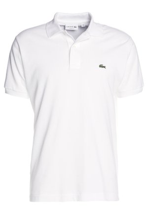 Camisa polo blanca de algodón con cuello clásico, mangas cortas y un pequeño logo de cocodrilo verde en el lado izquierdo del pecho. Diseño simple.