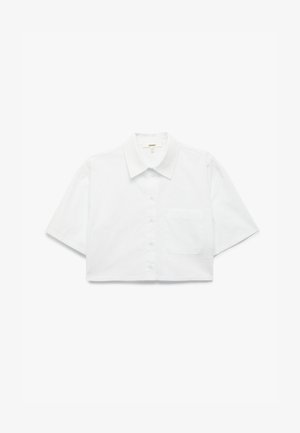Camisa corta de manga corta blanca y recortada con cuello y un solo bolsillo en el pecho, dispuesta plana sobre un fondo blanco.