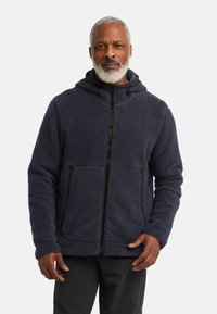 Giacca in pile di colore blu navy scuro, con chiusura con zip, cappuccio e due tasche frontali. Texture morbida con design a pannelli cuciti.