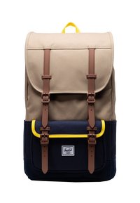 Kangaskauppa ruskeassa ja laivastonsinisessä värissä, jossa on kaksi ruskeaa nahkahihnaa, keltaisia korostuksia etutaskussa ja ylälaidassa suljettava läppä.