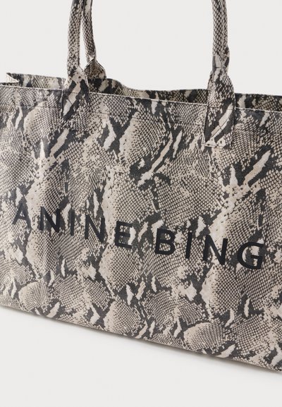 Tragetasche mit schwarz-weißem Schlangenledermuster und schwarzem Schriftzug "ANINE BING" auf der Vorderseite, ausgestattet mit zwei Stoffgriffen.