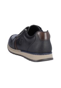 Scarpa in pelle nera con finitura texturizzata, dettaglio marrone nel tacco e zip laterale. Presenta una suola beige con un bordo blu.