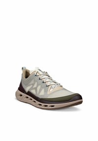 Sneaker sportiva beige e oliva con tomaia in mesh, dettagli laterali a motivo, suola ammortizzata con fori di ventilazione e lacci bianchi.