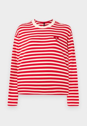 Langærmet crop top i rød og crema horisontale striber. Har en rund halsudskæring og et lille broderet logo på forsiden. Blødt stof.