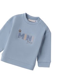 Felpa in cotone azzurro chiaro con maniche lunghe, scollatura rotonda e ricamo del testo 'MINI BANDA' con impronta di zampa. Dettaglio di chiusura laterale con bottoni a pressione.