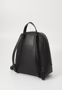 Black leather backpack with a smooth finish, rounded shape, dual shoulder straps, and a top handle. Features a silver zipper closure.