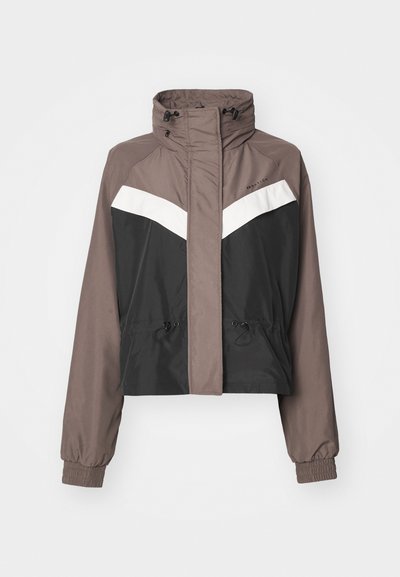 Cropped jacket in brown and black with white chevron design, adjustable drawstrings at waist, high collar, and elastic cuffs.