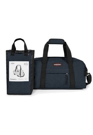 Compact blue duffle bag with black accents, featuring sturdy handles, a front zip pocket, and a tag displaying dimensions and volume.