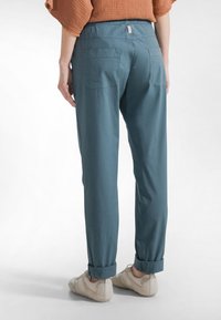 Lättviktsbyxor i teal med elastisk midja, uppvikta muddar, två bakfickor och en diskret logotypetikett vid midjan.