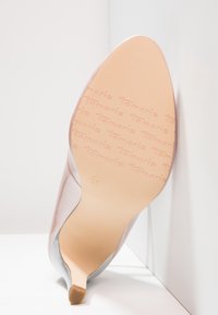 Scarpa con tacco alto di colore nudo, con una tomaia liscia in materiale sintetico e punta affusolata. La suola presenta un marchio in rilievo e un indicatore di taglia di 36.