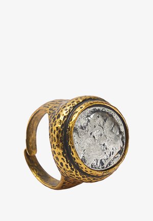 Pierścionek w kolorze złotym z teksturowaną obręczą i wyraźnym srebrnym kamieniem z misternym wzorem wypukłym. Regulowany projekt odpowiedni do różnych rozmiarów.