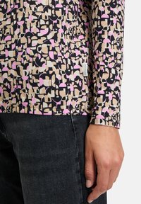 Langärmliges Oberteil mit geometrischem Muster in Rosa, Beige und Schwarz, aus weichem Stoff gefertigt, mit taillierter Passform und minimalen Nähdetails.