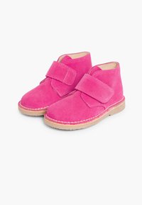 Botine roz din suede, cu curea Velcro, vârf rotund și talpă din cauciuc bej. Materialul texturat oferă un aspect moale.