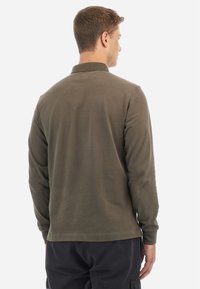 Hosszú ujjú, olajzöld pamut póló ing, laza fazonnal, klasszikus gallérral és tiszta varrással a hátsó részen és az ujjak mentén.