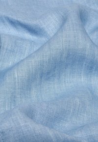 Helles blaues Leinengewebe mit einer weichen, strukturierten Oberfläche und einem subtilen Webmuster. Der Stoff wirkt leicht und fließend.