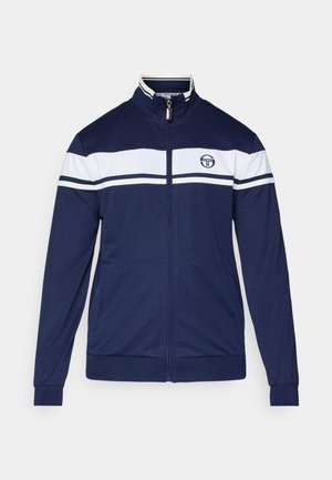 Giacca zip-up blu marina con strisce bianche sul petto. Presenta un colletto rialzato, tasche laterali e un logo vicino al collo. Tessuto liscio.