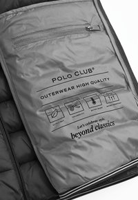 Grå vadderad inredning av en jacka med textetiketter för "ultralätt", "anpassad passform", "extra varm" och "vattentålig". Dragkedjeficka ingår.