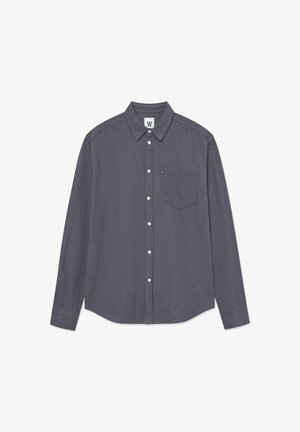 Cămașă gri cu mânecă lungă, guler cu nasturi, buzunar frontal și textură ribotată subtilă. Are nasturi pe toată fața și la manșete.