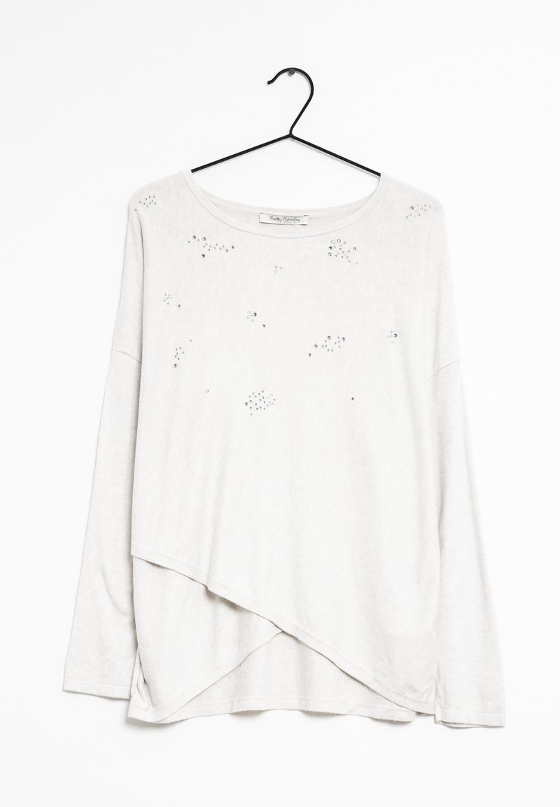 Ljust grå långärmad topp med rundad halsringning, asymmetrisk nederkant och spridda metallnitar som dekoration. Hänger på en svart krok.