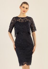 Marineblaue Spitzenkleid mit kurzen Ärmeln, mit gewelltem Saum und mehrschichtigem Design. Strukturierter Blumenmuster durchgehend. Figurbetonte Silhouette.